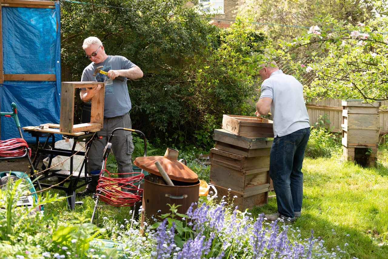 Mick and a volunteer rebuilding hives in the garden of Head Office.